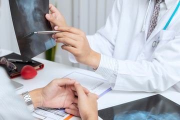 Medical and health care  concept. Doctor explaining x-ray results to patient while sitting at the...