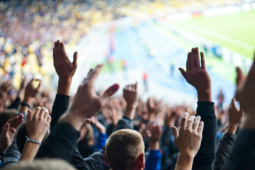 Football- soccer fans support their team and celebrate goal in full stadium with open air.