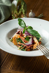 Close up view on Panzanella or panmolle - popular italian chopped salad of soaked stale bread, onions and tomatoes inwhite bowl on wooden background. Flat lay food
