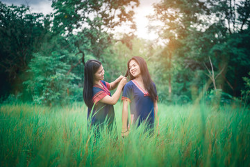 Portrait of young girls enjoy playing in the mist of foresst outdoor at countryside of Thailand