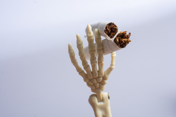 Skeleton figure breaking a cigarette. Smoking kills.