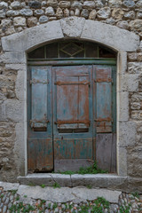 Old wooden door painted blue in the village of Labeaume in Ardeche, France.