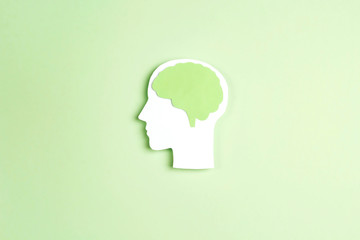 Silhouette human head with brain on green background.