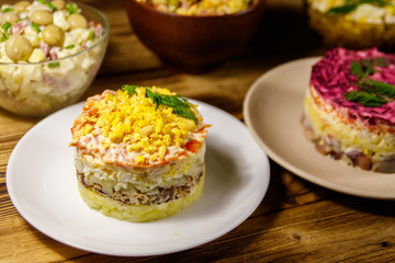 Set of festive mayonnaise salads on wooden table