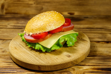 Fresh delicious homemade cheeseburger on wooden table