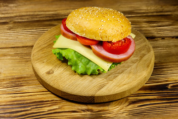 Fresh delicious homemade cheeseburger on wooden table