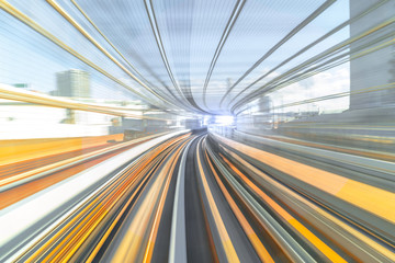 Fototapeta na wymiar Motion blur of speed train moving in tunnel with light at end.