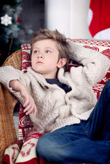 boy at Christmas by the fireplace and Christmas tree