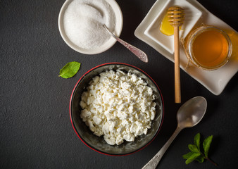 Fresh white cottage cheese in a bowl on the table. Tasty and healthy breakfast. dark stone surface. View from above. A lot of space for text.