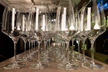 Crystal clear empty wine glasses on the table. Alcohol background. A lot of wine glasses at the bar.