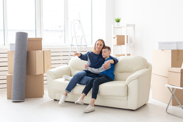 Young cute single mother and son are happy about the move to new house. Concept of housewarming and family space extensions.