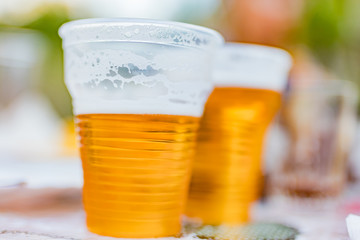 Beer glasses on a picnic table in the backyard.