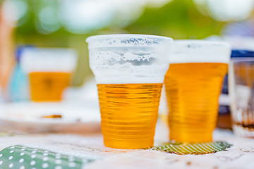 Beer glasses on a picnic table in the backyard.