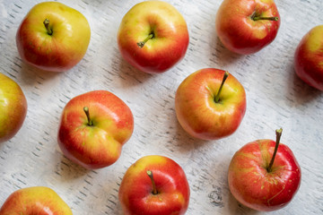 Flat lay of crabapples on a white washed wood background