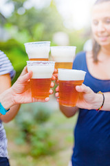 Friends enjoying drinking beer in the backyard.