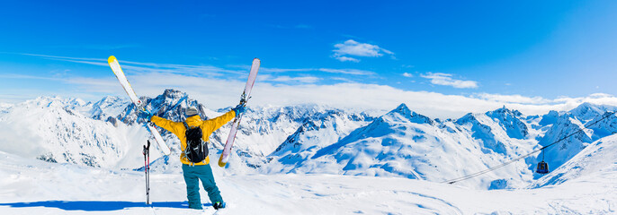 Ski in winter season, mountains and ski touring equipments on the top in sunny day in France, Alps above the clouds.