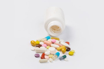 Assorted pharmaceutical medicine pills, tablets and capsules.Heap of assorted various medicine tablets and pills different colors on white background. Top view.Copy space