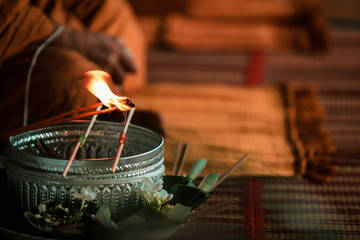 Fototapeta na wymiar Thai religious rituals : hands of monks, Candles used in ceremonies and Offering