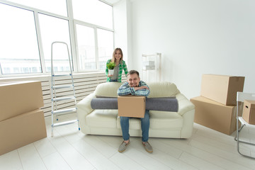Relocation, real estate and moving concept - Young cheerful couple moving into their new home