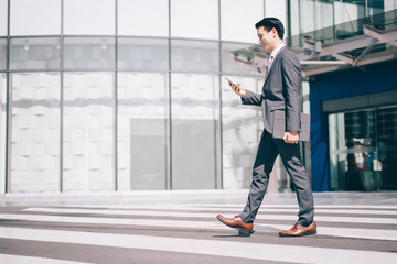 Fototapeta na wymiar Asian business man using on smart phone traveling walking inside in airport.