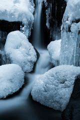 details of a frozen creek in heavy winter