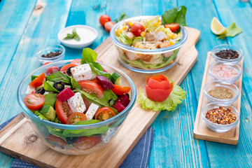 Mixed Vegetable Salads on Blue Wood Background - Mixed Gourmet Food , Mixed Healthy Food - Chicken Salad / Cheese Salad - Green leaves / Salad with Lettuce Leafs on Top and Cherry Tomatoes