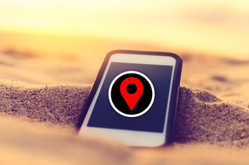 Smart phone and sand sunset beach with red navigator gps location abstract background. Copy space...