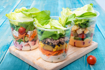 Mixed Vegetable Salads on Blue Wood Board - Mixed Gourmet Food , Mixed Healthy Food - Chicken Salad / Tuna Salad / Cheese Salad - Green leaves / Salad with Lettuce Leafs on Top