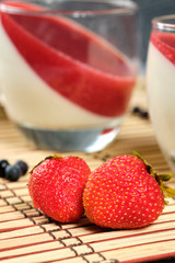 Strawberry and blueberry berries close-up on a straw napkin on a gray background. Selective focus