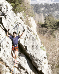 A man is walking along a stretched sling. Highline in the mountains. Man catches balance. Performance of a tightrope walker in nature. Highliner on the background of the mountains.