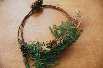 Christmas rustic wreath. Creative rural christmas wreath with fir branches, berries, pine cones and...