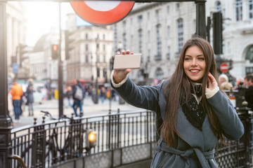 Touristin am Piccadilly Circus in London machr Selfie Fotos von sich auf einen Sightseeing Trip...