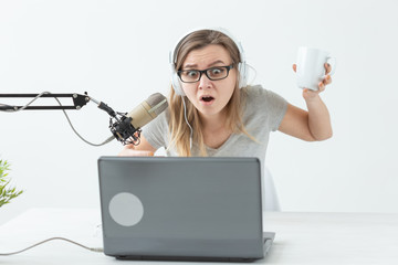 Radio, DJ, blogging and people concept - Smiling woman sitting in front of microphone, host at radio