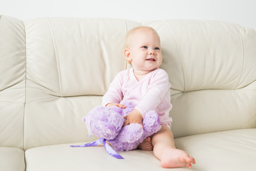 Child, childhood and kids concept - Portrait of charming baby girl on the couch