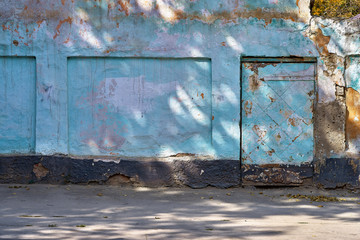 street wall and door background, aging blue facade of an abandoned fence