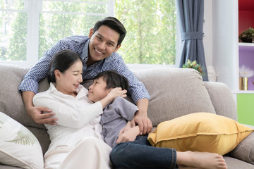 Asian family father, mother and son smiling together in living room, happy family concept
