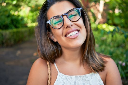 Young beatiful woman smiling happy and cheerful at green park on a sunny day of summer