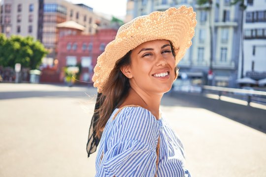 Young beautiful woman smiling happy walking on city streets on a sunny day of summer
