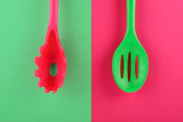 bright kitchen utensils on red and green background, creative idea