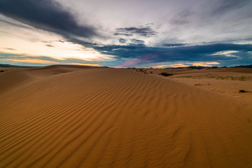 Obraz na płótnie Canvas Sunset over the sand dunes in the desert