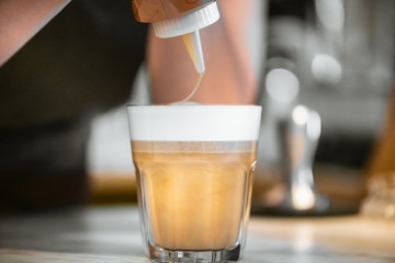 hands Barista steaming milk in pitcher.preparing steam milk by coffee machine to make latte art in cafe.latte is a coffee drink made from espresso and steamed milk.cup of latte coffee.