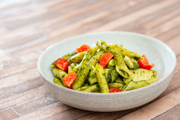 Pasta with pesto sauce and nuts on a the table