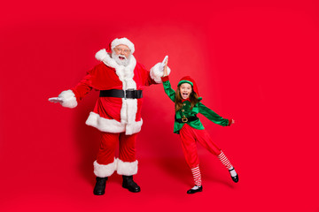 Full size photo of crazy santa claus elf having headwear eyewear eyeglasses spectacles celebrate success on noel preparation wearing green costume isolated over red background