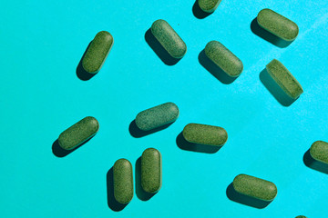 medicinal capsules, pills and tablets on blue background. Healthcare or medicament addiction concept. 