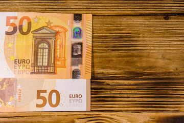 Fifty euro banknotes on the wooden background. Top view