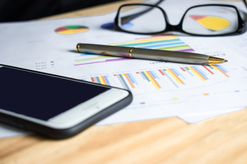 A side view of the financial graph of a business man on a wooden table. Financial concept. Close up.