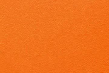 Orange color concrete cement wall with detail of rough stucco for background and design art work.