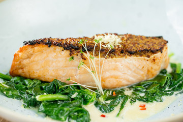 Salmon steak fillet and garnished with spinach. Restaurant menu, a series of photos of different dishes