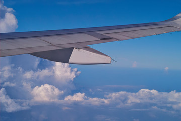 Obraz premium wing of an airplane flying above clouds