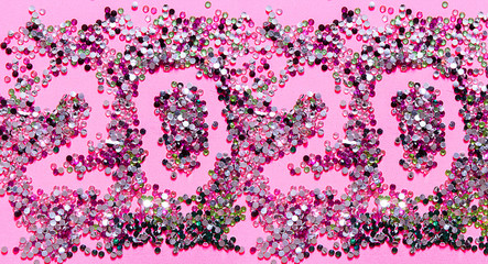 2020 inscription on a pink background from glitter, the concept of Christmas and New Year, holiday card